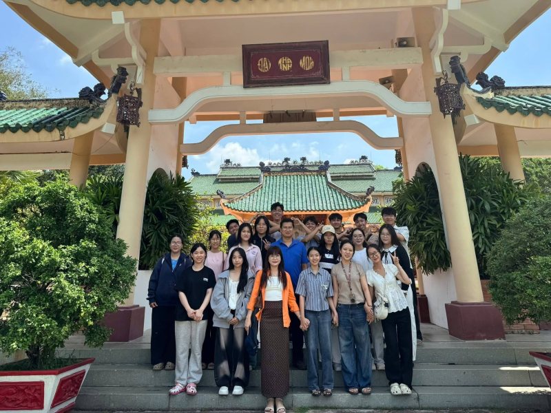 Thầy cô và học sinh chụp ảnh tập thể trước cổng mái ngói xanh